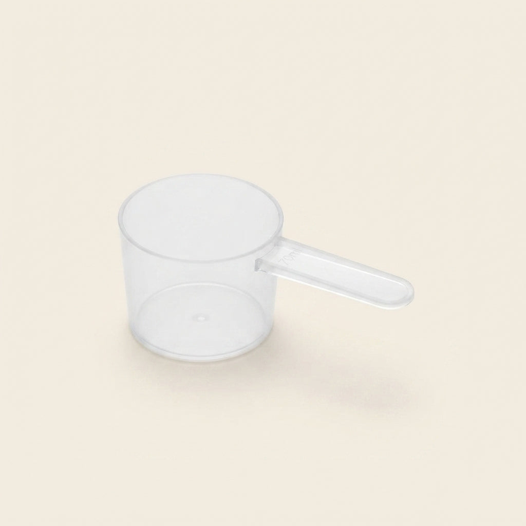 Doseuse graduée 70ml La Dose Facile Meraqi Homecare pour lessive liquide naturelle, vue produit sur fond beige
