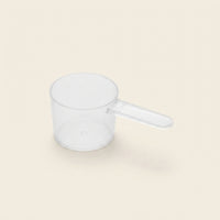 Doseuse graduée 70ml La Dose Facile Meraqi Homecare pour lessive liquide naturelle, vue produit sur fond beige