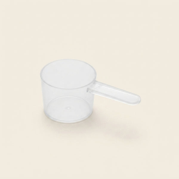 Doseuse graduée 70ml La Dose Facile Meraqi Homecare pour lessive liquide naturelle, vue produit sur fond beige
